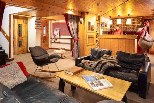 - un salon avec des fauteuils en cuir et une table dans l'établissement Hôtel du Bourg, à Valmorel