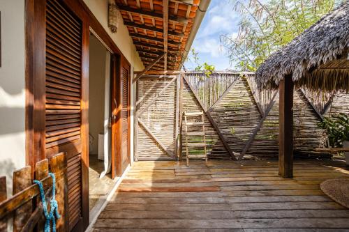 an entrance to a house with a wooden walkway at La Cozinha Bungalow in Barra Grande