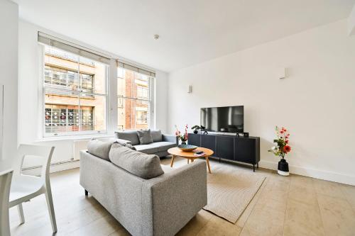 a living room with a couch and a table at Farringdon Comfortable 2 Bed Apartments in London