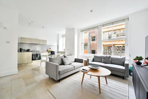 a living room with two couches and a table at Farringdon Comfortable 2 Bed Apartments in London