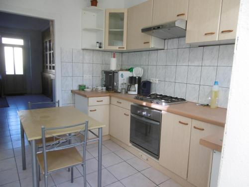 a kitchen with a table and a stove top oven at Sylvia's house - ground floor flat in Jarnages