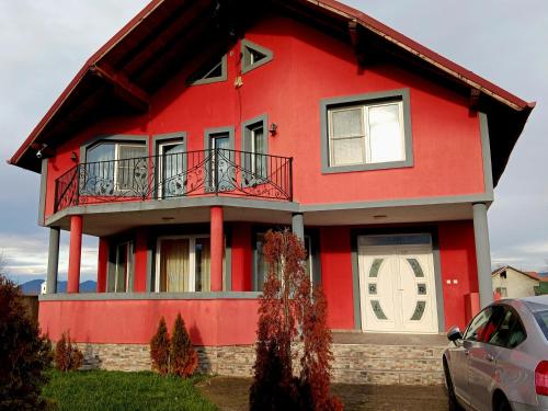 a red house with a car parked in front of it at VILA LUXURY in Tur