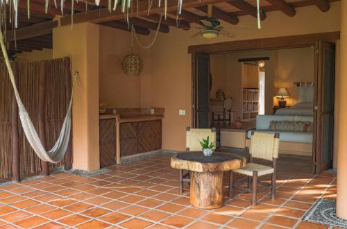 a room with a table and chairs and a bedroom at Puertas Paraíso Hotel boutique in Zihuatanejo