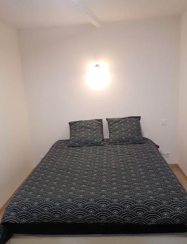 a bedroom with a large bed with two pillows at Sublime maison en pierre 12 pers in Miniac-Morvan