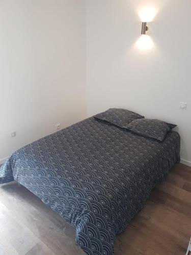 a bed with a black comforter in a room at Sublime maison en pierre 12 pers in Miniac-Morvan