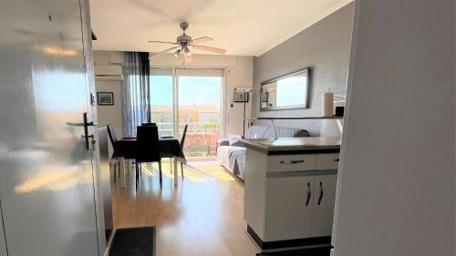 Cette chambre comprend une cuisine et une salle à manger avec une table. dans l'établissement Appartement deux pièces Port La Nouvelle PN020-031, à Port-la-Nouvelle