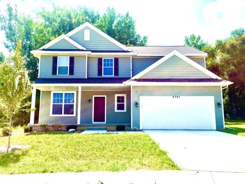 a blue house with a white garage at Newly Built Spacious Quiet 3 Bed Rm House with Backyard and Parking in Midland