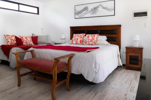 a bedroom with a large bed and a chair at Casa Maqui in Santa Cruz