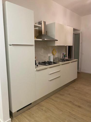 a kitchen with white cabinets and a refrigerator at Via Piave 98 in Cosenza