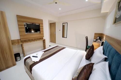 a bedroom with a bed and a tv on the wall at HOTEL ALFA EXECUTIVE in Mumbai