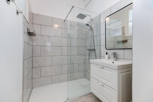 une salle de bain blanche avec une douche et un lavabo dans l'établissement Elegant Condo with Balconies in the Heart of Nice, à Nice