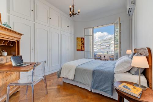 une chambre avec un lit et un bureau avec un ordinateur portable dans l'établissement Elegant Condo with Balconies in the Heart of Nice, à Nice