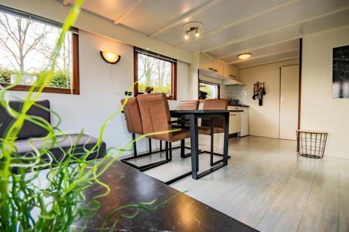 a dining room and living room with a table and chairs at 'Hunebed Chalet' - De Tien Heugten in Schoonloo