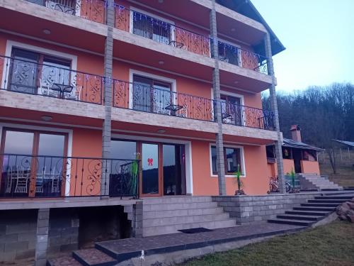 a building with balconies and stairs in front of it at Casa Jazmin Covasna in Covasna