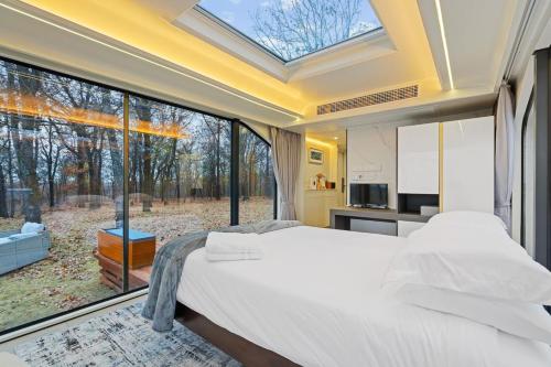 a bedroom with a bed and a large window at Paradise Point on Arkansas River Pod with Fire Pit in Muskogee