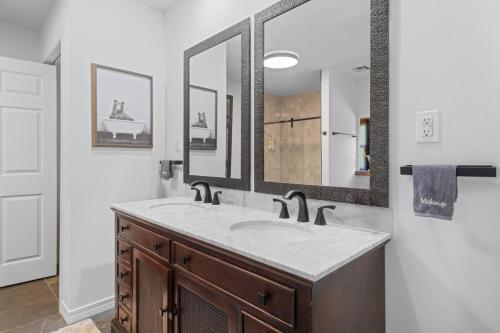 a bathroom with a sink and a large mirror at Twisted Tree with Arkansas River Views and Hot Tub in Muskogee