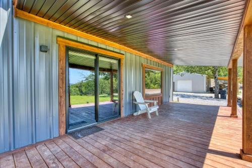 a house with a deck with sliding glass doors at Twisted Tree with Arkansas River Views and Hot Tub in Muskogee