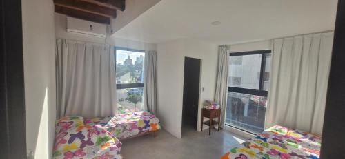 a bedroom with two beds and a large window at Vivisierras, Duplex a estrenar con pileta privada centro Villa Carlos Paz, 3 dormitorios, 2 baños, vista in Villa Carlos Paz