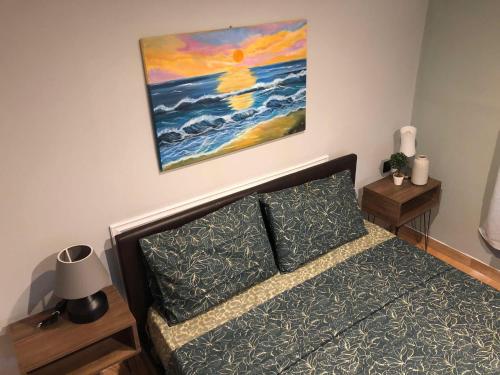 a bedroom with a bed and a painting on the wall at Cozy Home Kanali, Preveza in Kanali