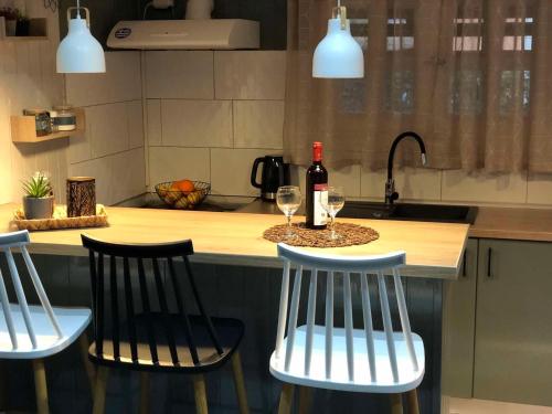 a kitchen with two chairs and a counter with wine glasses at Cozy Home Kanali, Preveza in Kanali