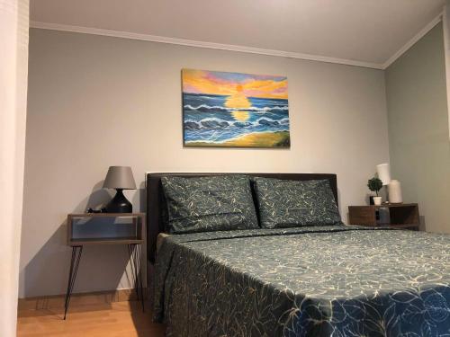 a bedroom with a bed and a painting on the wall at Cozy Home Kanali, Preveza in Kanali