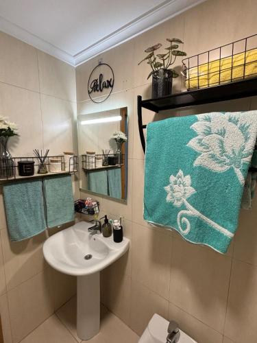 a bathroom with a sink and a blue towel at El pisuco in Miengo