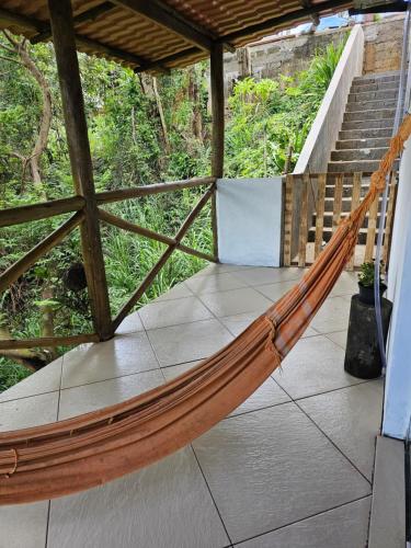 a hammock on a porch with a staircase at Suite dos pássaros in Ilhabela