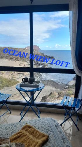 a bedroom with a view of the ocean from a window at Los Abrigos 2 apartments Guest House Ocean relax, wifi, playas in Los Abrigos