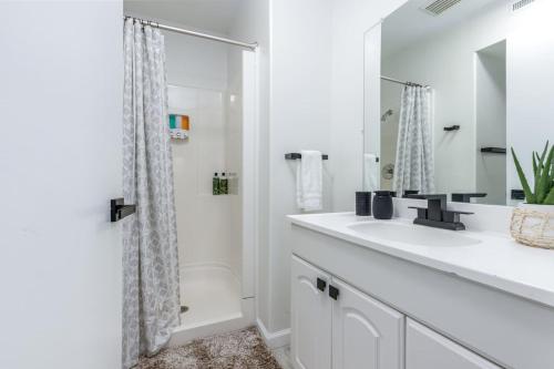 Un baño blanco con ducha y lavabo. en DO with AC 3 Suites Waterfront Marina Home, en Atlantic City