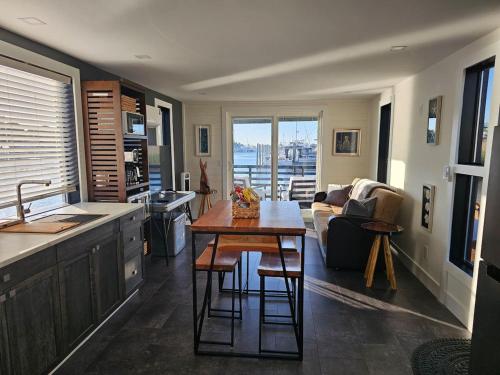 a kitchen and living room with a table and a couch at Panama Float Home Riverfront Fire Pit in Forked River