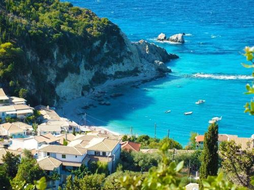 Una vista de una playa con casas y el océano. en Myrto Homes Lefkada Agios Nikitas Greece, en Agios Nikitas