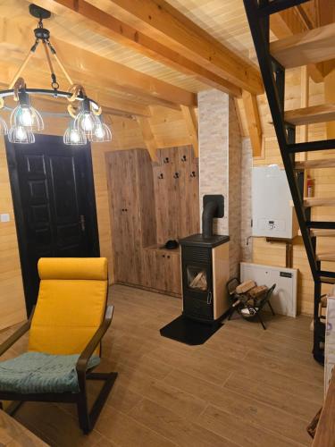 a living room with a wood stove and a chair at Vikendica Villa Marija Pale in Pale