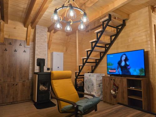 a living room with a yellow chair and a tv at Vikendica Villa Marija Pale in Pale
