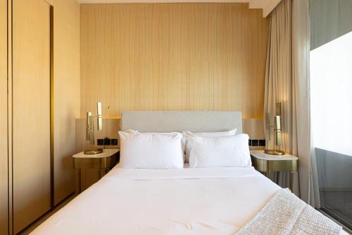 a bedroom with a large white bed with two tables at *Five Palm* 2bdr Private Beach in Dubai
