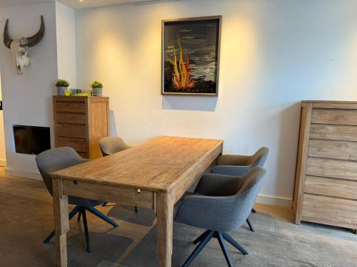 a dining room table with chairs and a painting on the wall at Stylish 1-Bedroom Apartment in Eindhoven in Eindhoven