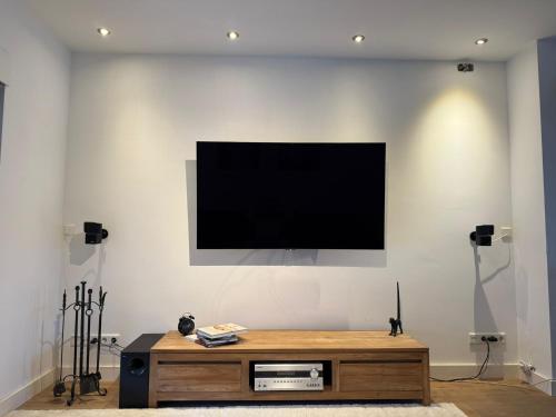 a living room with a television on a white wall at Stylish 1-Bedroom Apartment in Eindhoven in Eindhoven