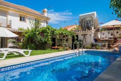 a swimming pool in front of a house at At Home in Malaga Stay & Solo Travellers in Rincón de la Victoria