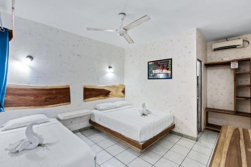 タマリンドにあるHotel Tamarindo INN - 1 mi to Tamarindo Beachのベッド2台と天井ファン付きの寝室