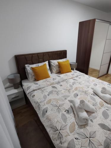 a bedroom with a bed with yellow pillows at Stan na dan Sunce in Bijeljina