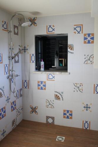 a bathroom with a shower with blue and white tiles at Regina in Peso