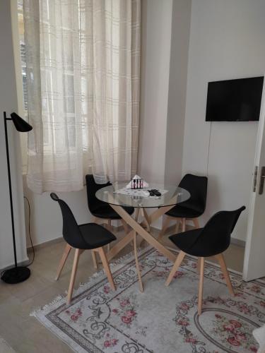 a dining room with a glass table and chairs at DORA'S APARTMENTS STUDIO 1 in Corfu Town