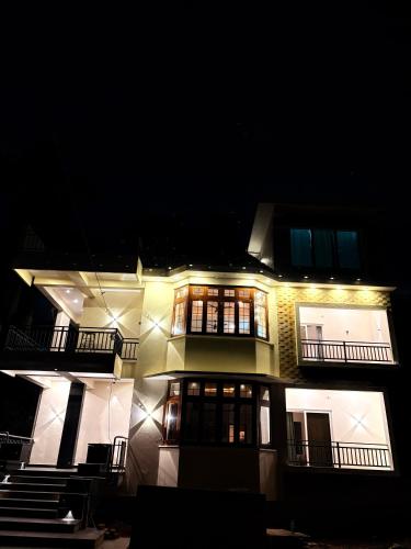 a large building with lights on it at night at Ameya Coorg Home Stay in Madikeri