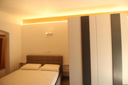 - une petite chambre avec 2 lits et un placard dans l'établissement PietraViva, à Porte di Rendena