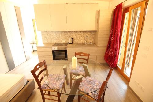 une cuisine avec une table en verre et des chaises dans une pièce dans l'établissement PietraViva, à Porte di Rendena