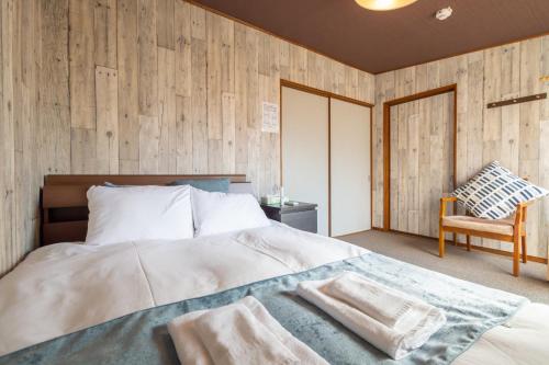 a bedroom with a bed with a wooden wall at 二条駅から徒歩10分 in Kyoto