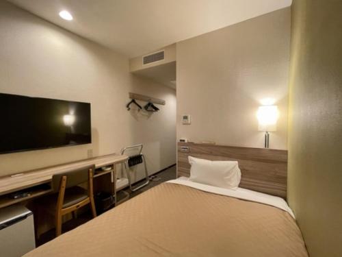 a hotel room with a bed and a flat screen tv at Kusatsu Daiichi Hotel - Vacation STAY 99256v in Kusatsu