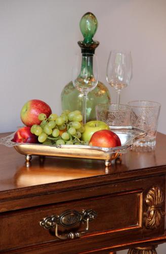 a tray of fruit on a table with wine glasses at The Gregoire Boutique Villa in Hermanus