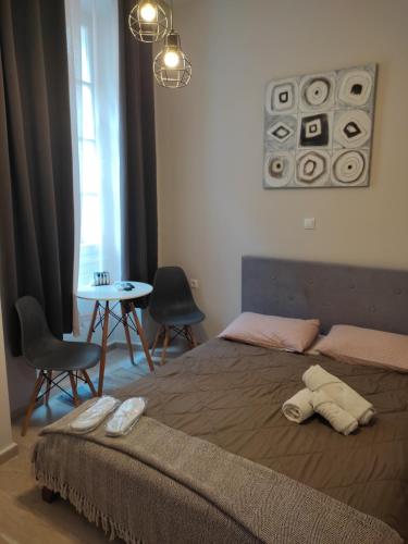 a bedroom with a bed with two chairs and a table at DORA'S APARTMENTS STUDIO 1 in Corfu Town