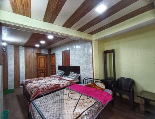奈尼塔尔JK Guest House的一间卧室配有两张床和椅子