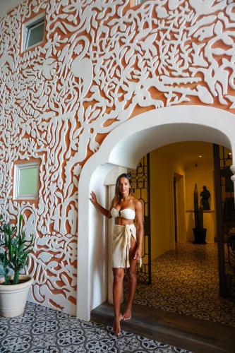 a woman standing in front of a wall at Casa Tortugas Boutique Hotel - A Hidden Gem in Cancun in Cancún